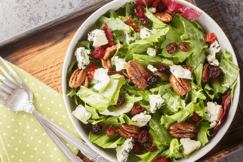 Fresh green salad topped with blue cheese, pecans, and dried cherries