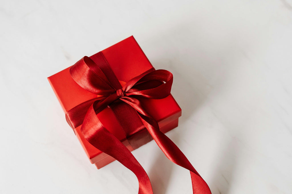 A red corporate gift box with a satin bow