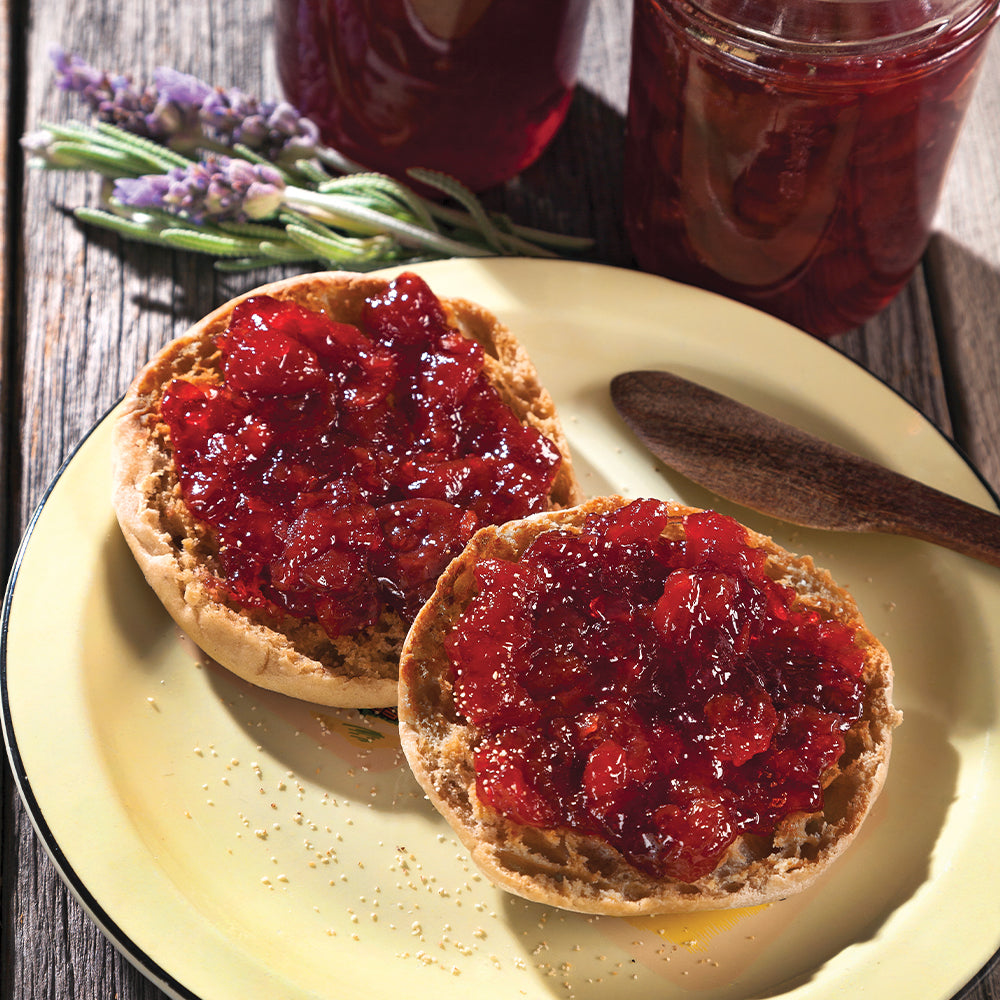 A plate with muffins topped with cherry jam